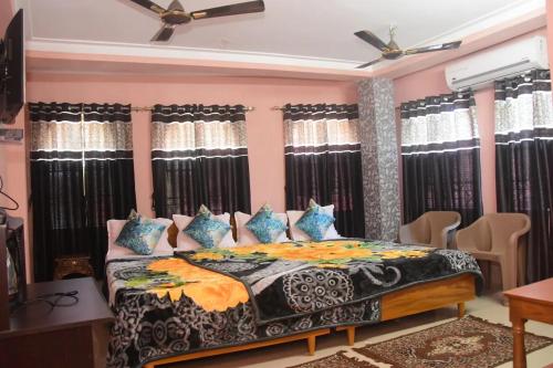 een slaapkamer met een groot bed met blauwe kussens bij HOTEL ROYALE in Calcutta
