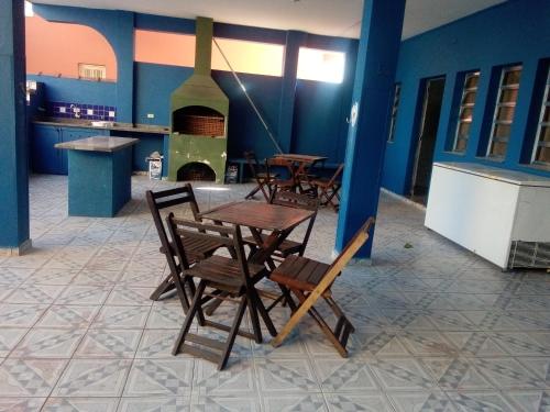 een tafel en stoelen in een keuken met een fornuis bij Casa aconchegante de praia in Itanhaém