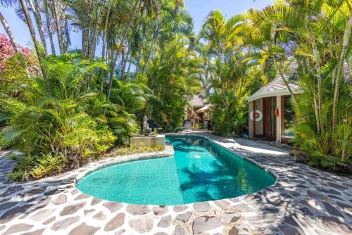 an image of a swimming pool in a backyard with palm trees at Lavish Cliff House with Ocean Views in Haiku, Maui jungle in Huelo