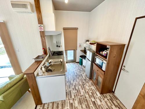 uma pequena cozinha com um lavatório e um balcão em Beach Villa Tachibana em Onomichi