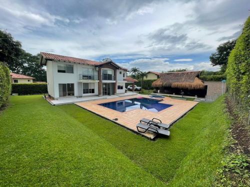 a backyard with a swimming pool and a house at comfortable country house in Pereira