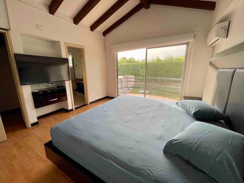 a large bedroom with a large bed and a large window at comfortable country house in Pereira