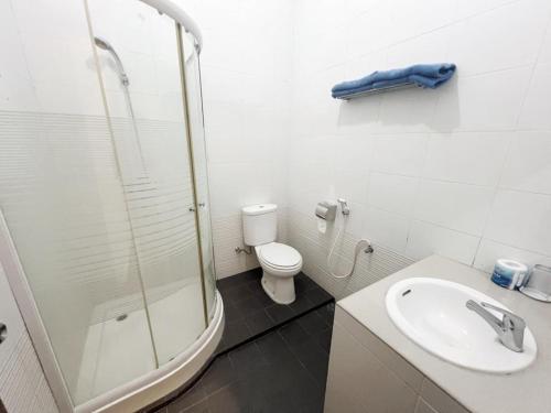 a bathroom with a shower and a toilet and a sink at OASE GUEST HOUSE in Medan