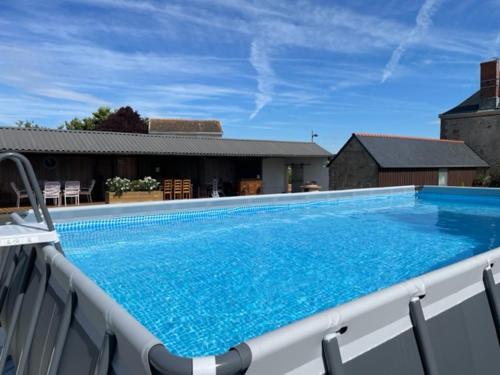 - une grande piscine bleue installée au-dessus d'une maison dans l'établissement Le Logis de Laura, à Trémont
