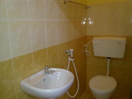 ein Badezimmer mit einem weißen Waschbecken und einem WC in der Unterkunft ILHAMVILLA GUEST HOUSE Binjai Kubang Kerian 