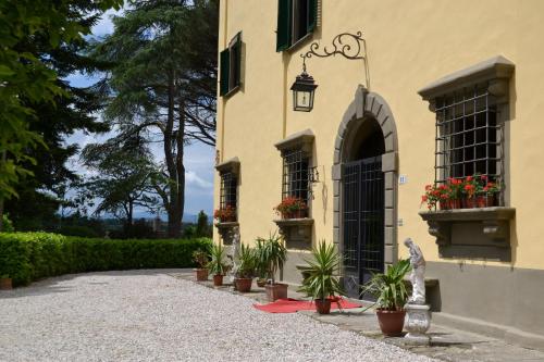 a building with potted plants on the side of it at Villa Aurora di Ferracciano in Borgo San Lorenzo
