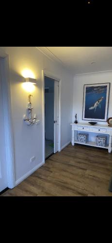 a living room with a television on a wall at Sapphire Lodge in Bermagui