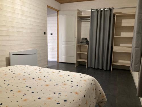 ein Schlafzimmer mit einem Bett in einem Zimmer mit Regalen in der Unterkunft Le Chalet de cyprès in Saint-Louis
