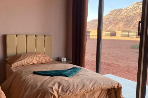 a bedroom with a bed with a view of the desert at Welcome to Wadi Rum Camp in Wadi Rum