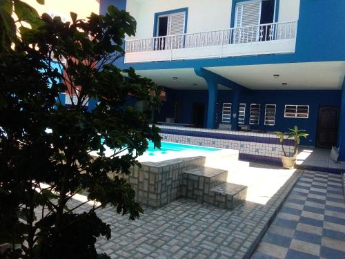 een huis met een zwembad en een gebouw bij Casa aconchegante de praia in Itanhaém