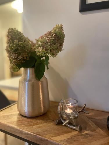 a vase with flowers on a table with a candle at Weberhof-Münster 2 in Münster
