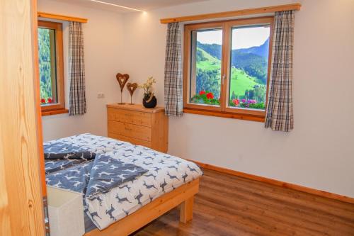 1 dormitorio con 1 cama y 2 ventanas en Salzburger Bergklause, en Weissbach bei Lofer