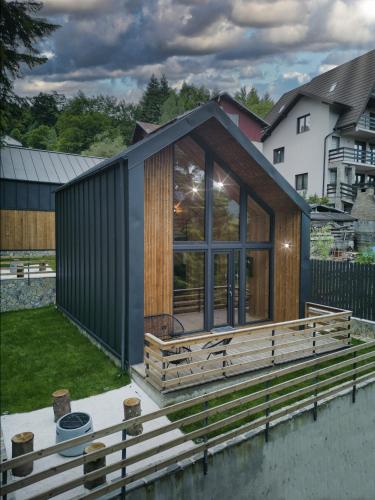 mały dom z tarasem i dużym oknem w obiekcie Norway Cabins w mieście Sinaia