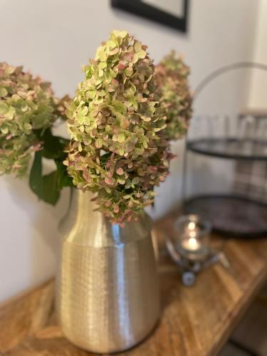 a silver vase with flowers in it on a table at Weberhof-Münster 2 in Münster