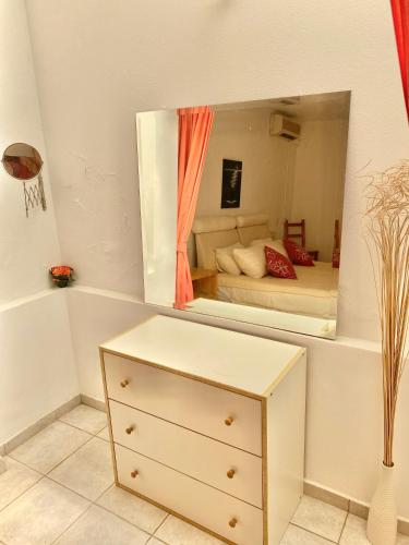 a bedroom with a dresser and a large mirror at 2 Bedroom, Sea Side Retreat Saronida in Saronida