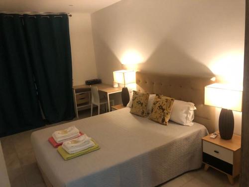 a bedroom with a bed with two lamps and two tables at Villalina : Cosy, piscine privée, proche Grand Baie et plages in Pereybere
