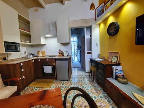 a kitchen with yellow walls and a counter top at Bizzilla Lodging Suite in Mqabba