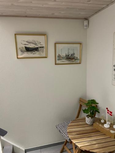 a dining room with a wooden table and two pictures on the wall at Happy Fisherman BnB in Aalborg
