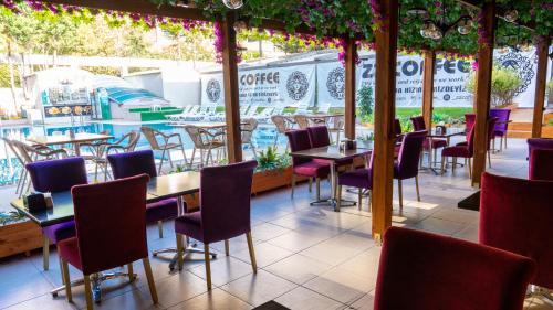 a restaurant with tables and chairs and a pool at Gardan Hotel in Beylikduzu