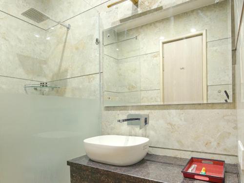 Un baño con lavabo blanco y ducha. en Hotel Golden Stay, en Amritsar