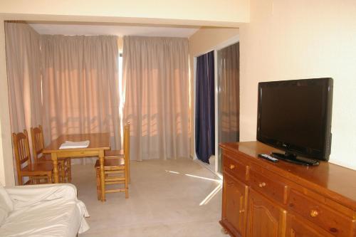 una sala de estar con TV de pantalla plana en una cómoda en Apartamentos Torre Levante - Arca Rent, en Benidorm