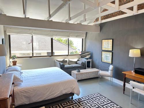 um quarto com uma cama e uma sala de estar em Green Point Self Catering Studios na Cidade do Cabo