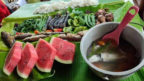 a plate of food with a bowl of soup and watermelon at LABUYO FARM 