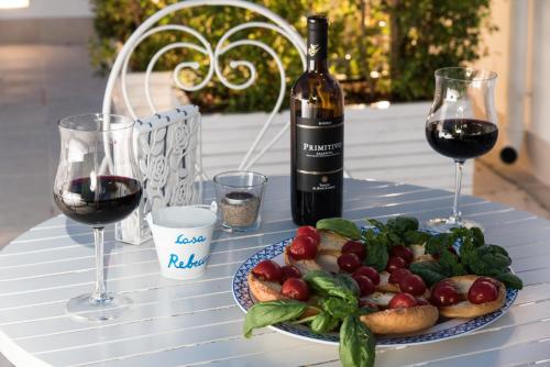 een tafel met een bord eten en een fles wijn bij Casa Rebecca in Monopoli