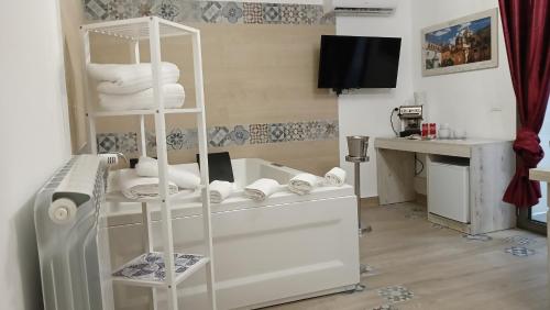 una camera con mensola bianca e asciugamani bianchi di Sicily Rooms Appartamenti a Carini