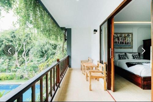 a bedroom with a bed and a balcony with a pool at Tinggian Hill Retreat in Nusa Penida