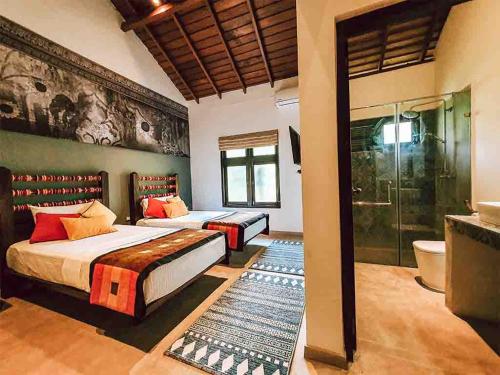 a bedroom with two beds and a shower at Serendib Signature Resort in Digana