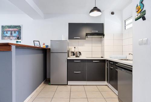 a kitchen with stainless steel appliances and black cabinets at Saint-leu Réunion centre ville T3 Duplex meublé in Saint-Leu