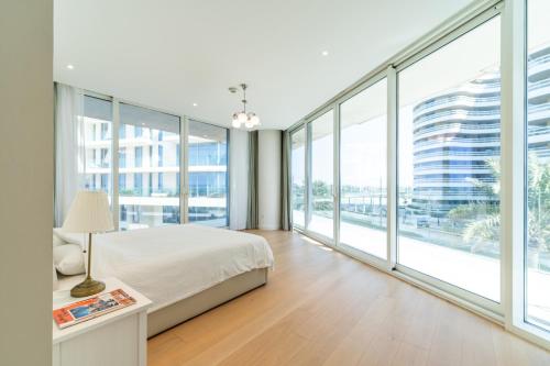 a bedroom with a bed and large windows at Luxury, 3 bedrooms, Saadiyat Island, spacious, beach & pool, restaurants, gym in Abu Dhabi