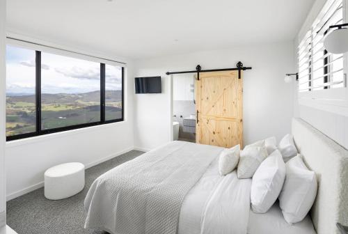 um quarto branco com uma cama grande e uma janela em The Bella Vista by Mt Bellevue em Myrrhee