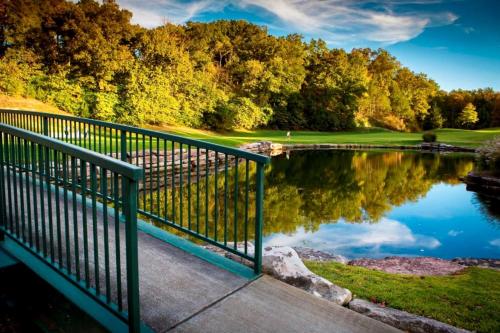 a view of a golf course with a pond at Rest Haven in Branson West