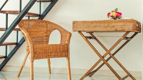 a wicker chair and a desk with a vase of flowers at Majoong Pool Villa Pension in Gyeongju