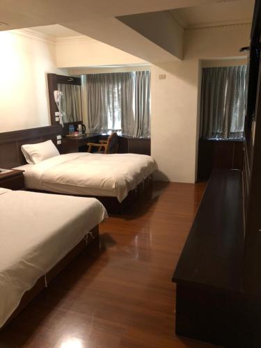 a hotel room with two beds and a desk at 奇萊大飯店 Chuline Hotel in Hualien City