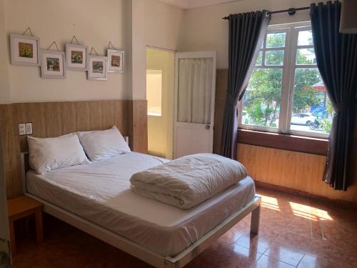 a bed in a room with a window and a bed sidx sidx sidx at iDorm B&B - idorm Mỹ in Da Lat