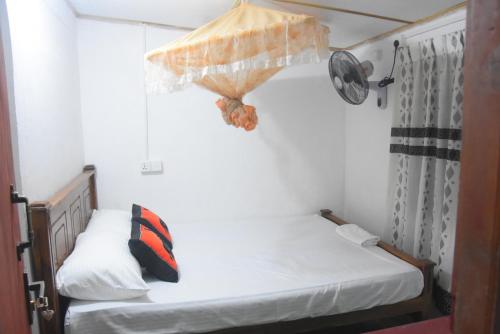 1 dormitorio con 2 camas y sombrilla en Meera Homestay, en Anuradhapura