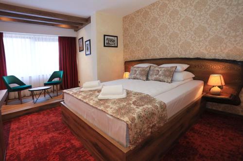 ゼニツァにあるCarpe Diem Boutique Hotelの大きなベッド、テーブル、椅子が備わるホテルルームです。