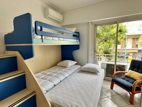 a bedroom with a bunk bed and a chair at Spacieux appartement face mer in Menton