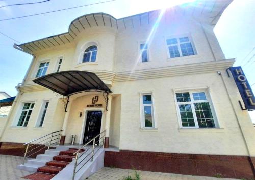 a large white building with stairs in front of it at Home Boutique Hotel in Tashkent