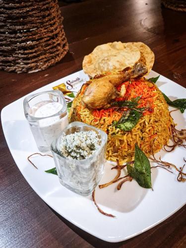 a plate of food with meat and rice on a table at Serendib Signature Resort in Digana