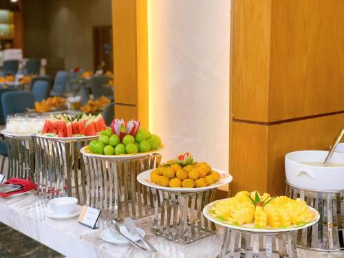 a row of plates of fruit on a table at Muong Thanh Luxury Nhat Le Hotel in Dong Hoi