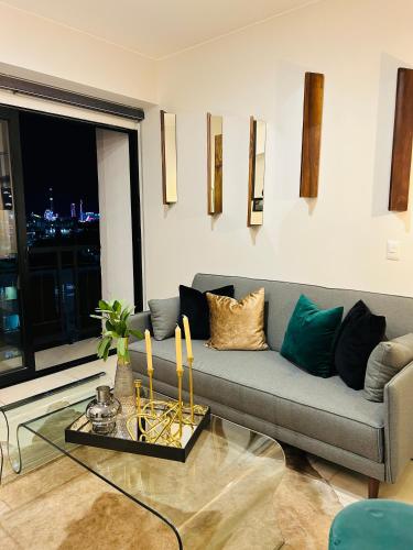 a living room with a couch and a glass table at Hermoso Departamento de Lujo cerca del Auditorio Telmex in Guadalajara