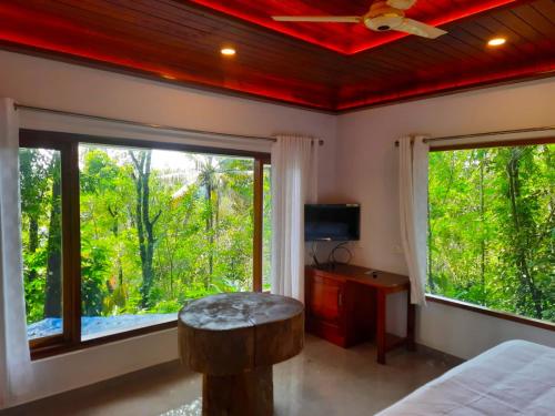 1 dormitorio con cama y ventana grande en kurinjiyil Farm Stay Munnar en Munnar