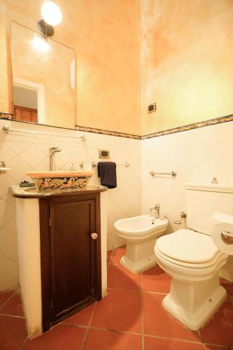 a bathroom with a toilet and a sink with a mirror at Casa Fabio in Syracuse