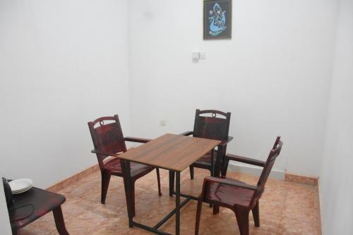 une salle à manger avec une table en bois et quatre chaises dans l'établissement Lion Home Stay Anuradhapura, à Anurâdhapura