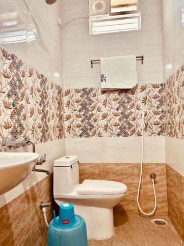 a bathroom with a toilet and a sink at Hotel Sitar Grand in Tirupati