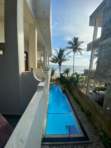 a swimming pool with a view of the beach at Virage Beach House @ Morava Court in Hikkaduwa